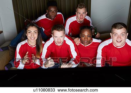 Stock Image - Group Of Sports Fans Watching Game On TV At Home. Fotosearch