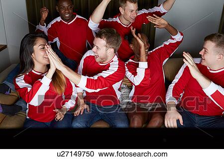 Stock Image - Group Of Sports Fans Watching Game On TV At Home. Fotosearch