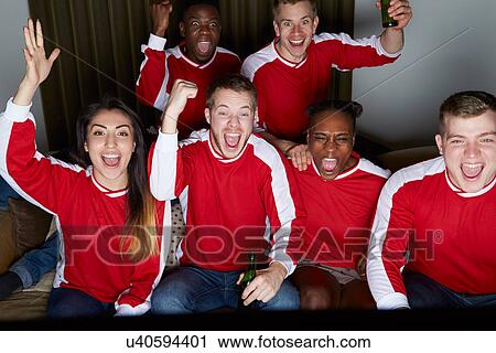 Stock Image - Group Of Sports Fans Watching Game On TV At Home. Fotosearch