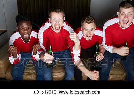 Stock Image - Group Of Sports Fans Watching Game On TV At Home. Fotosearch