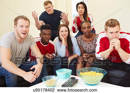 Stock Image - Group Of Sports Fans Watching Game On TV At Home. Fotosearch