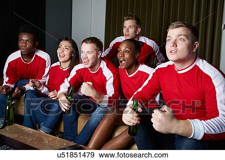 Stock Photo - Group Of Sports Fans Watching Game On TV At Home. Fotosearch