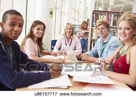 Group Of Students Working Together In Library With Teacher View Large Photo Image Stock Photo - Group Of Students Working Together In Library With Teacher. Fotosearch