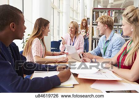 Group Of Students Working Together In Library With Teacher View Large Photo Image Stock Photograph - Group Of Students Working Together In Library With Teacher. Fotosearch
