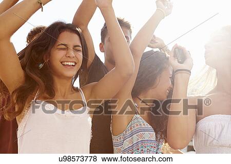 Group Of Teenage Friends Dancing Outdoors Against Sun View Large Photo Image Stock Photo - Group Of Teenage Friends Dancing Outdoors Against Sun. Fotosearch