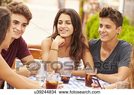 Picture - Group Of Teenage Friends Sitting Together At Cafe. Fotosearch