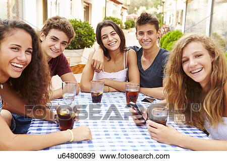 Group Of Teenage Friends Sitting Together At Cafe View Large Photo Image Stock Photo - Group Of Teenage Friends Sitting Together At Cafe. Fotosearch