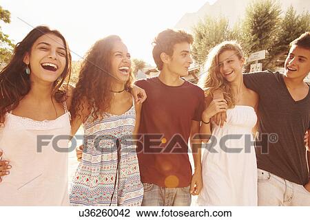 Stock Image - Group Of Teenage Friends Walking Along Street. Fotosearch