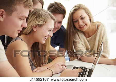 Group Of Teenagers Gathered Around Laptop Together View Large Photo Image Stock Photo - Group Of Teenagers Gathered Around Laptop Together. Fotosearch