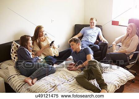 Stock Photography - Group Of Teenagers Relaxing In Bedroom. Fotosearch