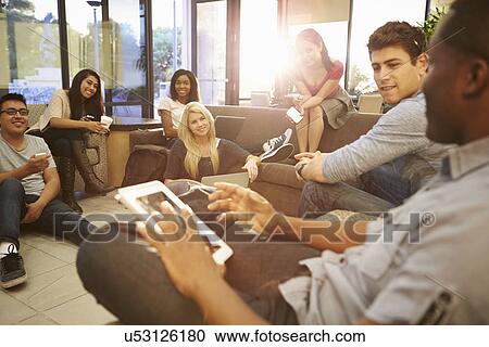 Stock Image - Group Of University Students Relaxing In Common Room. Fotosearch