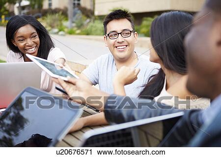 Group Of University Students Working On Project Outdoors View Large Photo Image Stock Image - Group Of University Students Working On Project Outdoors. Fotosearch