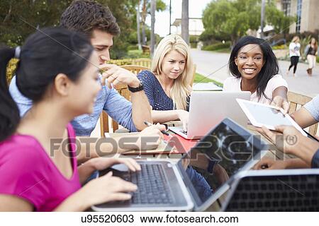 Stock Image - Group Of University Students Working On Project Outdoors. Fotosearch