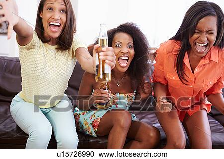 Group Of Women Sitting On Sofa Watching TV Together View Large Photo Image Stock Image - Group Of Women Sitting On Sofa Watching TV Together. Fotosearch