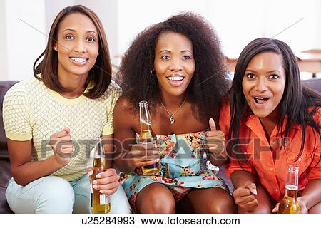 Group Of Women Sitting On Sofa Watching TV Together View Large Photo Image Stock Image - Group Of Women Sitting On Sofa Watching TV Together. Fotosearch