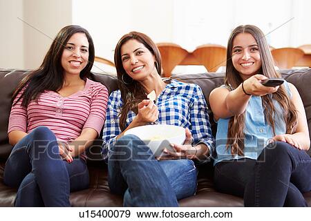 Stock Photo - Group Of Women Sitting On Sofa Watching TV Together. Fotosearch