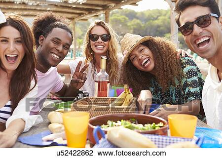 Group Of Young Friends Enjoying Lunch Outdoors View Large Photo Image Stock Image - Group Of Young Friends Enjoying Lunch Outdoors. Fotosearch