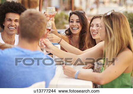 Picture - Group Of Young Friends Enjoying Meal In Outdoor Restaurant. Fotosearch
