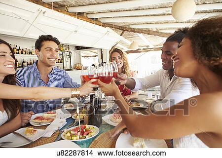 Group Of Young Friends Enjoying Meal In Outdoor Restaurant View Large Photo Image Picture - Group Of Young Friends Enjoying Meal In Outdoor Restaurant. Fotosearch