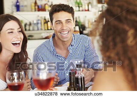 Group Of Young Friends Enjoying Meal In Outdoor Restaurant View Large Photo Image Stock Photo - Group Of Young Friends Enjoying Meal In Outdoor Restaurant. Fotosearch
