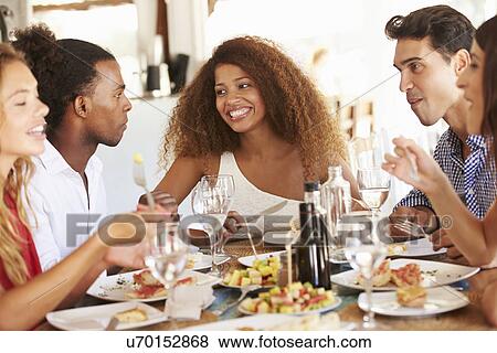 Group Of Young Friends Enjoying Meal In Outdoor Restaurant View Large Photo Image Stock Photo - Group Of Young Friends Enjoying Meal In Outdoor Restaurant. Fotosearch