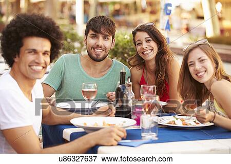 Group Of Young Friends Enjoying Meal In Outdoor Restaurant View Large Photo Image Stock Photo - Group Of Young Friends Enjoying Meal In Outdoor Restaurant. Fotosearch