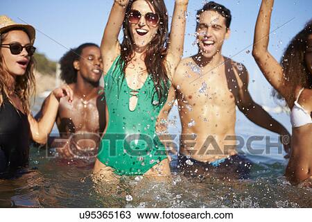 Stock Image - Group Of Young Friends Having Fun In Sea Together. Fotosearch