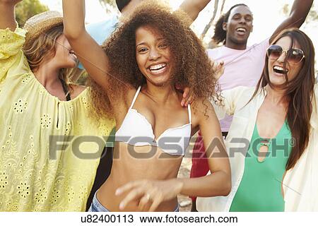 Stock Image - Group Of Young Friends Having Party On Beach Together. Fotosearch