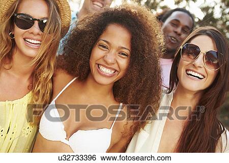 Stock Photograph - Group Of Young Friends Having Party On Beach Together. Fotosearch