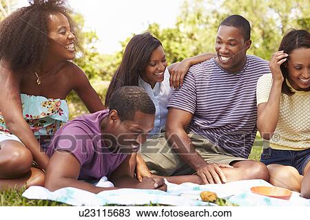Stock Image - Group Of Young Friends Having Picnic Together. Fotosearch