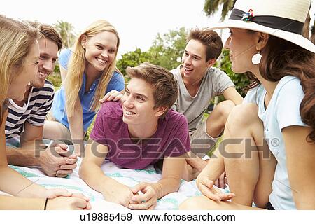 Stock Photo - Group Of Young Friends Having Picnic Together. Fotosearch