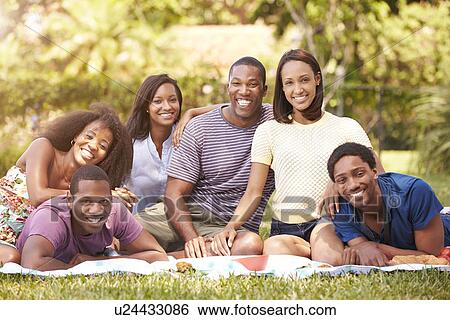 Stock Photograph - Group Of Young Friends Having Picnic Together. Fotosearch