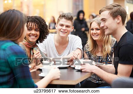 Group Of Young Friends Meeting In Cafe View Large Photo Image Stock Photo - Group Of Young Friends Meeting In Cafe. Fotosearch