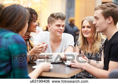 Stock Photo - Group Of Young Friends Meeting In Cafe. Fotosearch