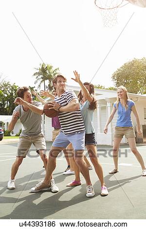 Stock Photograph - Group Of Young Friends Playing Basketball Match. Fotosearch