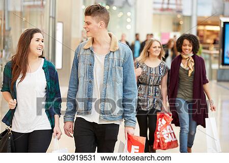 Stock Image - Group Of Young Friends Shopping In Mall Together. Fotosearch