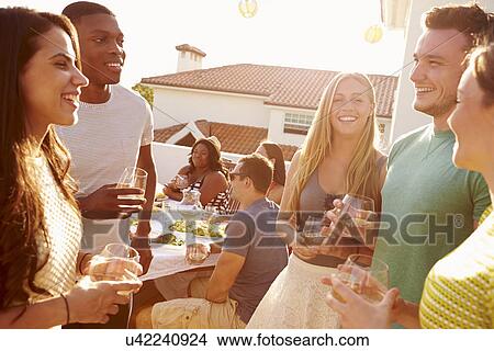 Picture - Group Of Young People Enjoying Outdoor Summer Meal. Fotosearch