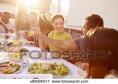 Group Of Young People Enjoying Outdoor Summer Meal View Large Photo Image Stock Photo - Group Of Young People Enjoying Outdoor Summer Meal. Fotosearch