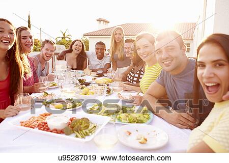 Group Of Young People Enjoying Outdoor Summer Meal View Large Photo Image Stock Photo - Group Of Young People Enjoying Outdoor Summer Meal. Fotosearch