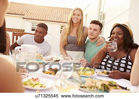 Group Of Young People Enjoying Outdoor Summer Meal View Large Photo Image Stock Photography - Group Of Young People Enjoying Outdoor Summer Meal. Fotosearch