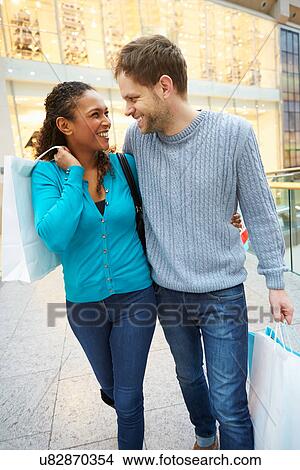 Happy Couple Carrying Bags In Shopping Mall View Large Photo Image Picture - Happy Couple Carrying Bags In Shopping Mall. Fotosearch