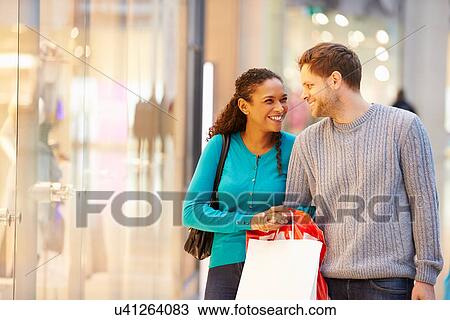 Happy Couple Carrying Bags In Shopping Mall View Large Photo Image Stock Image - Happy Couple Carrying Bags In Shopping Mall. Fotosearch