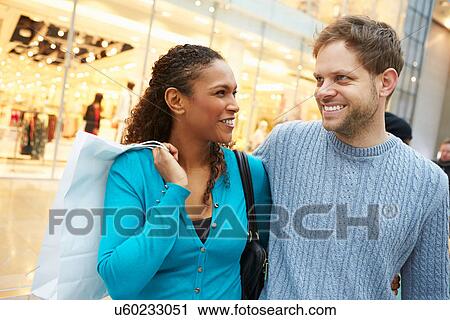 Happy Couple Carrying Bags In Shopping Mall View Large Photo Image Stock Image - Happy Couple Carrying Bags In Shopping Mall. Fotosearch