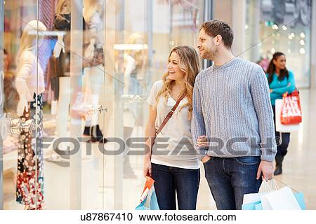 Happy Couple Carrying Bags In Shopping Mall View Large Photo Image Stock Image - Happy Couple Carrying Bags In Shopping Mall. Fotosearch