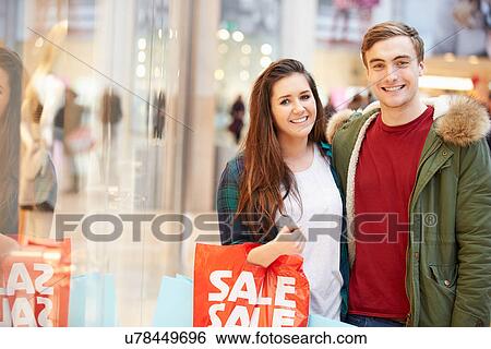 Happy Couple Carrying Bags In Shopping Mall View Large Photo Image Stock Photograph - Happy Couple Carrying Bags In Shopping Mall. Fotosearch