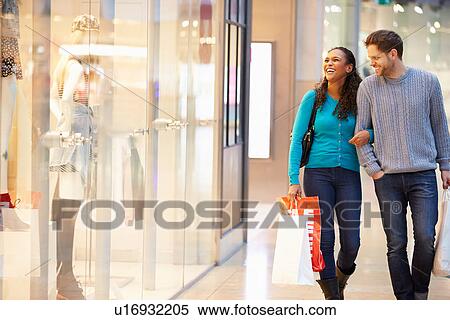 Happy Couple Carrying Bags In Shopping Mall View Large Photo Image Stock Photography - Happy Couple Carrying Bags In Shopping Mall. Fotosearch