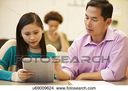 Picture - High School Student And Teacher Using Digital Tablet. Fotosearch