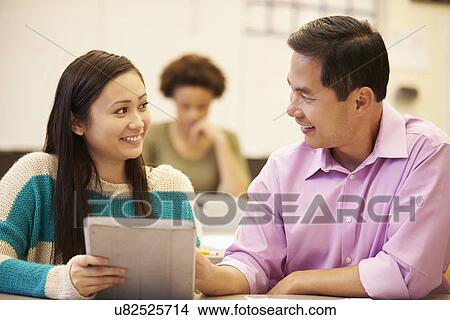 Picture - High School Student And Teacher Using Digital Tablet. Fotosearch