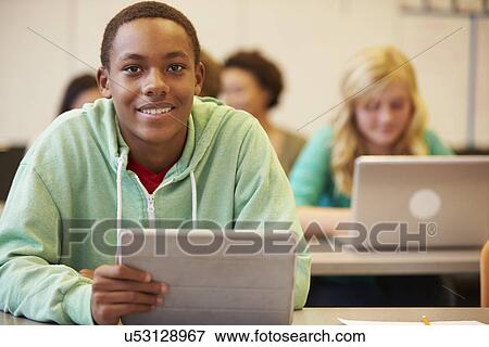 Stock Photo - High School Student At Desk In Class Using Digital Tablet. Fotosearch