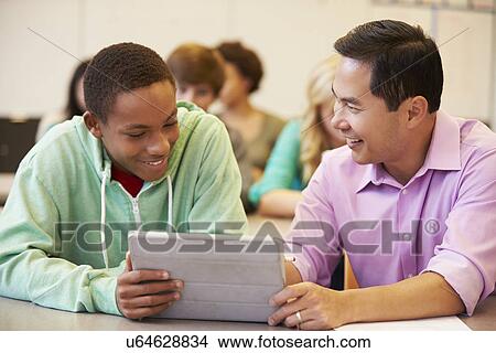 Picture - High School Student With Teacher Using Digital Tablet. Fotosearch